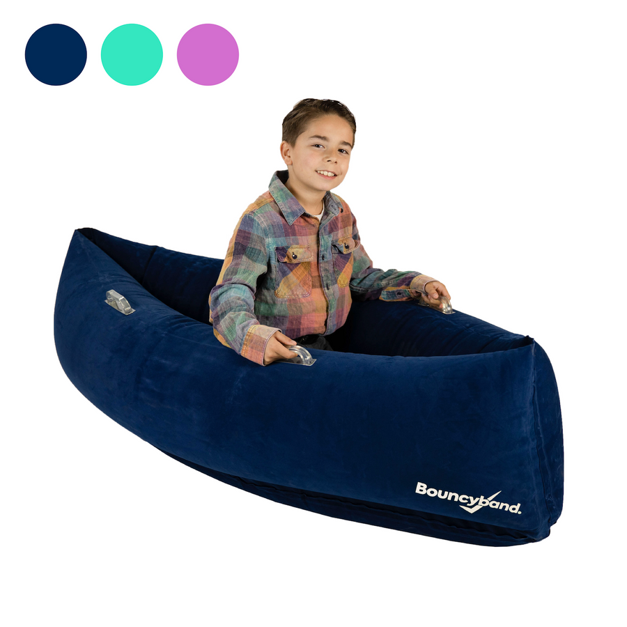 Child sitting in a dark blue inflatable sensory peapod, smiling and holding the sides. Three color swatches (navy, teal, purple) shown above.
